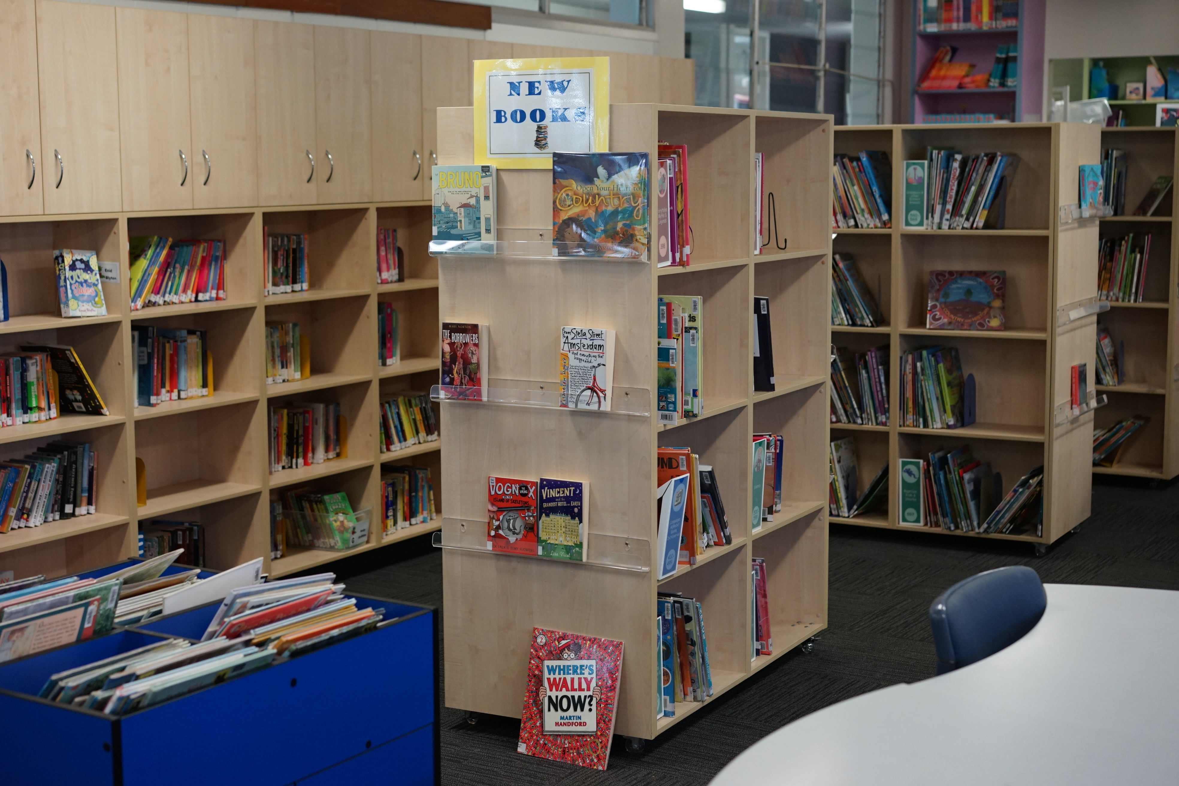 School library interior with bookshelves and a display of new books.