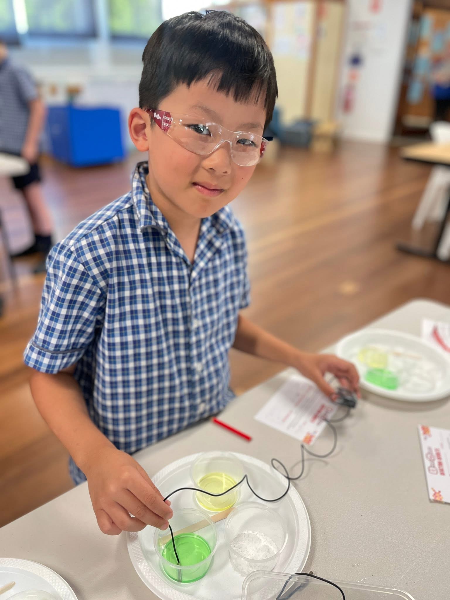 Student participating in a hands‑on science experiment in a classroom.