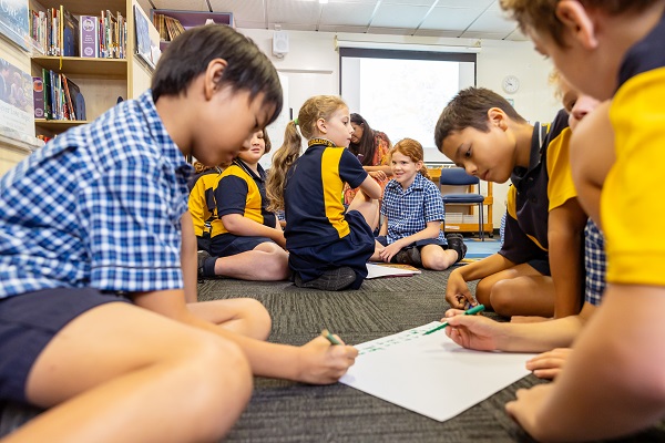 Students working collaboratively on a shared writing task in a classroom.