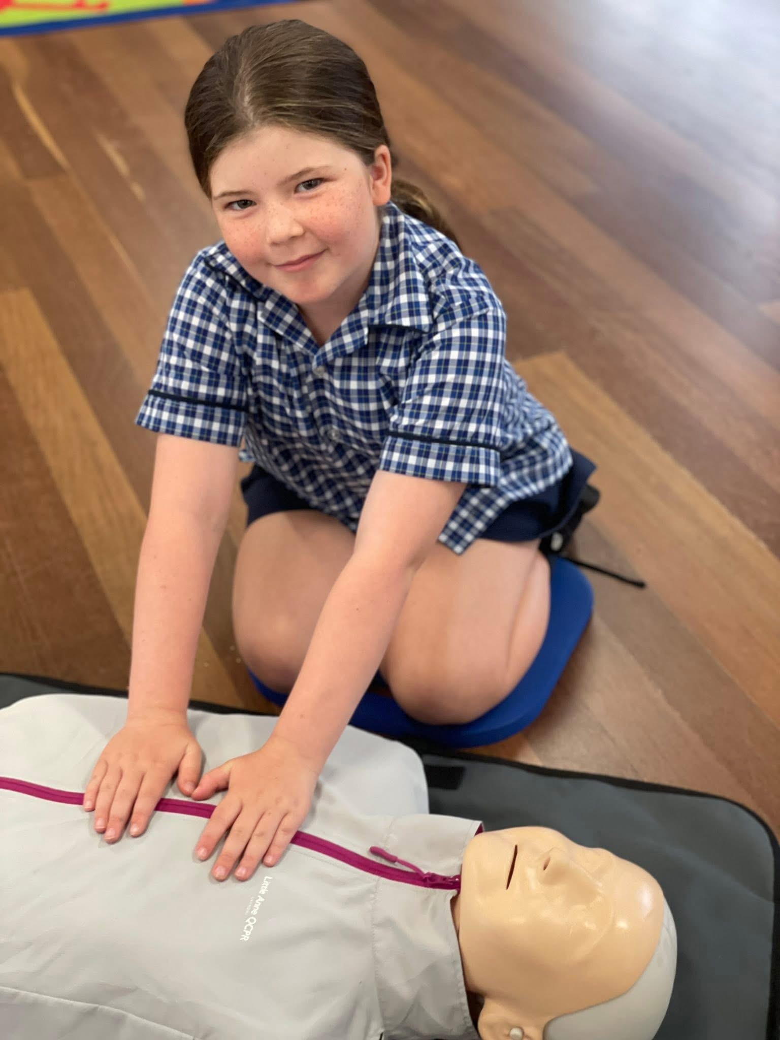 A student practicing on a CPR model